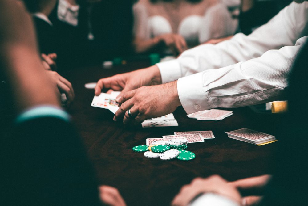 Pemain poker menata chip di atas meja hijau