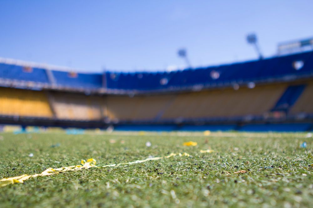 Lapangan sepak bola dengan stadion di latar belakang